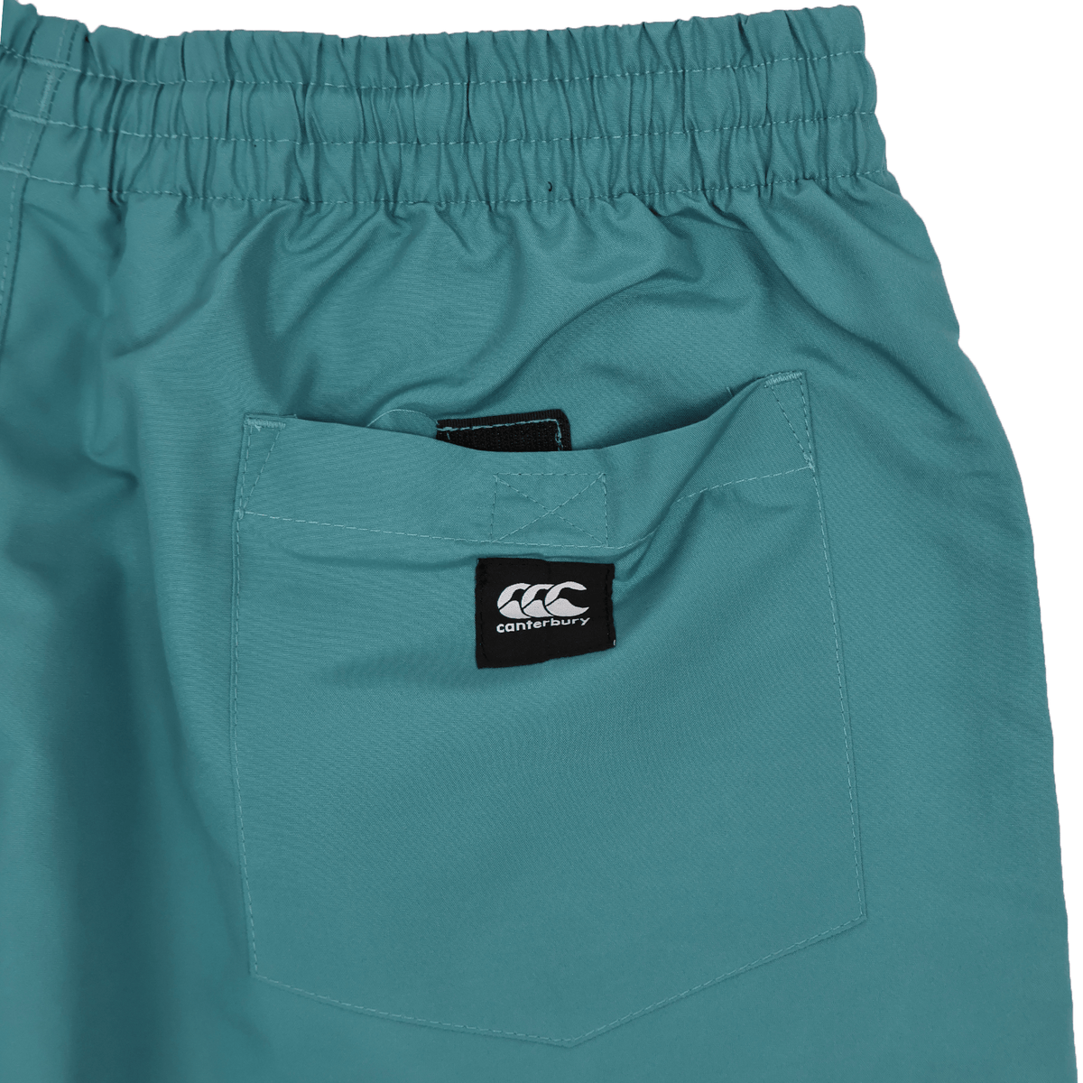 Close-up of teal Women's Canterbury Uglies Tactic Shorts with an elastic waistband, back pocket, and black Canterbury logo tag.