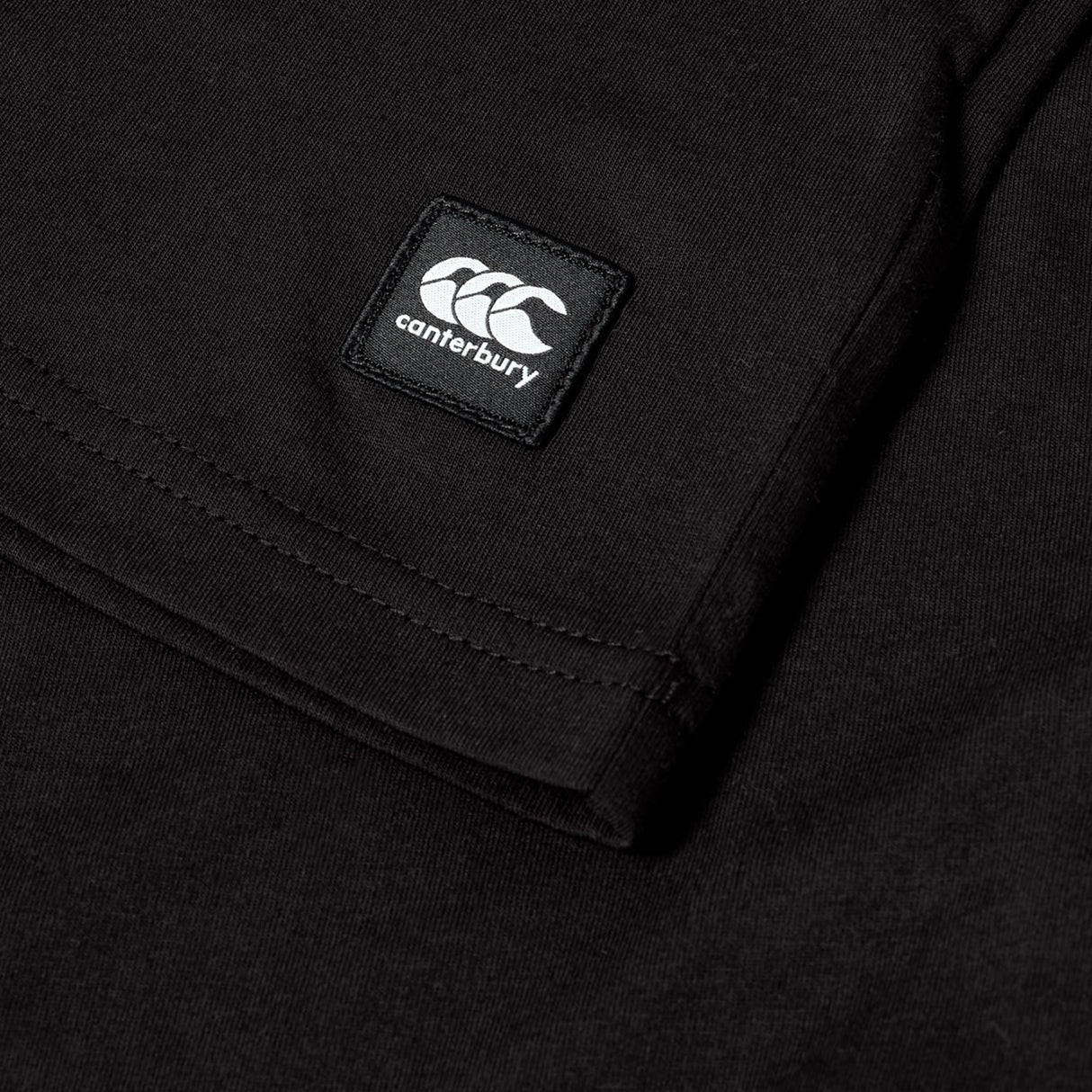 Close-up of the Youth Canterbury Uglies Logo T-shirt in black, crafted from comfortable cotton, featuring the white Canterbury logo on a patch near the sleeve.
