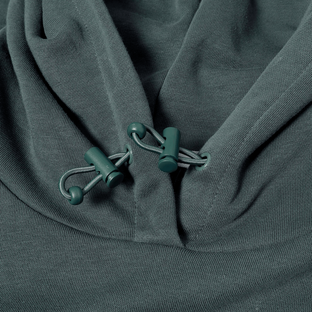 Close-up of the Canterbury FORCE HOODIE in teal, highlighting the hood’s drawstrings and plastic cord locks.