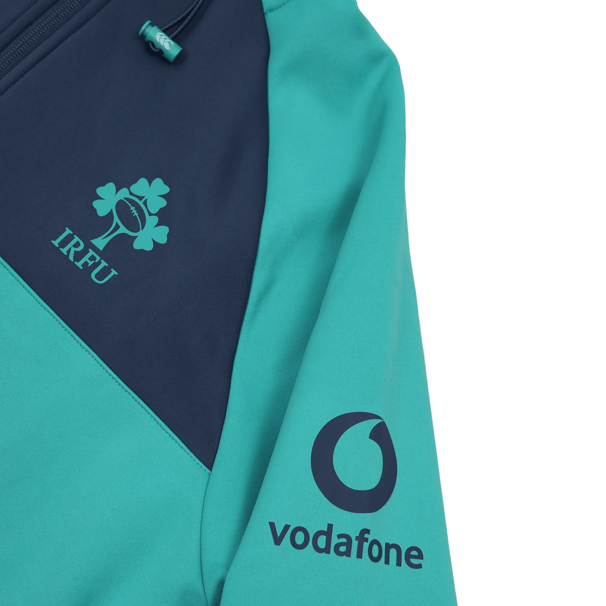 Close-up of the Ireland 26/27 Summer Tour Training Hoodie by Canterbury in teal and navy, showing the IRFU chest logo and Vodafone sleeve logo. This moisture-wicking Canterbury hoodie is built for high-performance training.