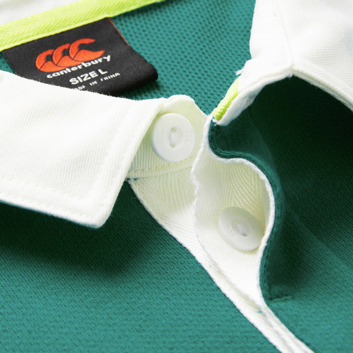 Close-up of the Ireland 26 Short Sleeve Home Classic Jersey by Canterbury in green and white, highlighting the collar, buttons, and a black size L label—a must-have for any Ireland rugby supporter.