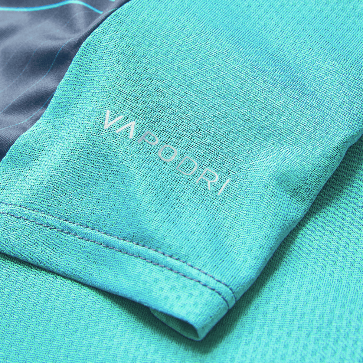 Close-up of a blue Ireland 26/27 Summer Tour Superlight Training Tee sleeve by Canterbury, showcasing the white "VAPODRI" logo.