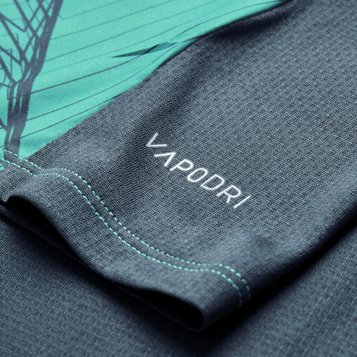 Close-up of the textured gray and teal fabric from the Canterbury Ireland 26/27 Summer Tour Superlight Training Tank, featuring "VAPODRI" in white lettering.