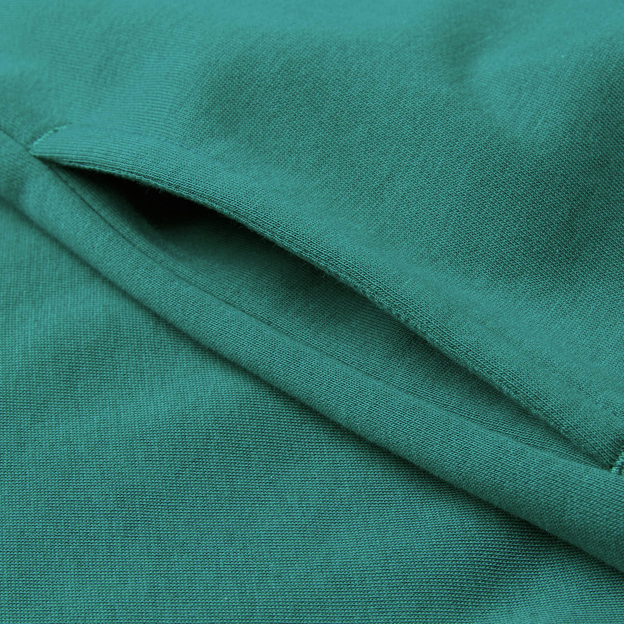 Close-up of a teal green fabric with a welt pocket, highlighting the stitching and texture of the material—perfectly featured in the Women’s Ireland 26 Legends 1/4 Zip Sweatshirt by Canterbury.