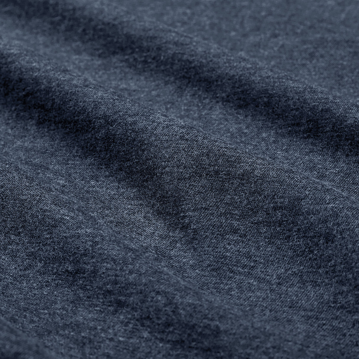 Close-up of dark gray heathered fabric from the Women’s Ireland 26 Cotton T-shirt by Canterbury, with visible texture and soft folds running diagonally across the surface.