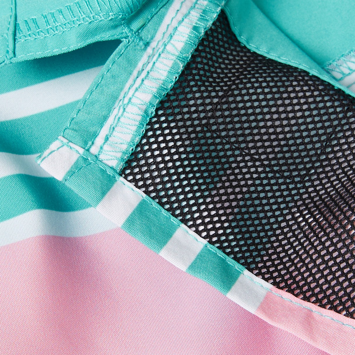 Close-up of Women's Canterbury Uglies Harletic Short by Canterbury, featuring pink, teal, and white stripes with a visible black mesh lining, in the style of durable athletic shorts.