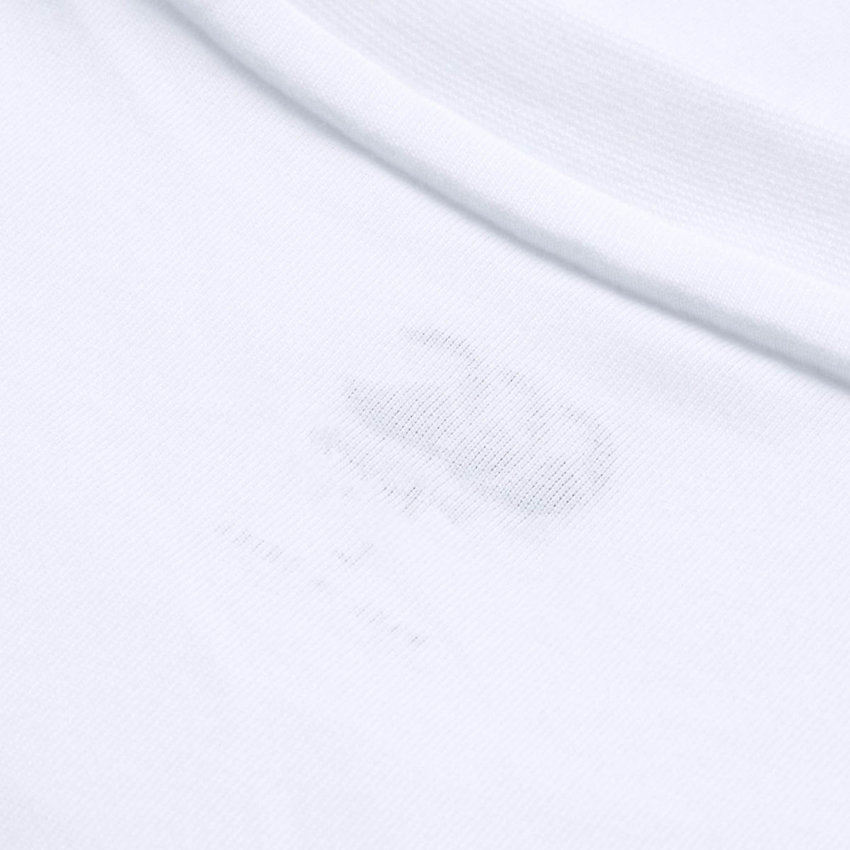 Close-up of the Canterbury Tempo+ GFX Training T-Shirt collar in white, highlighting a faint printed label inside the fabric near the neckline.