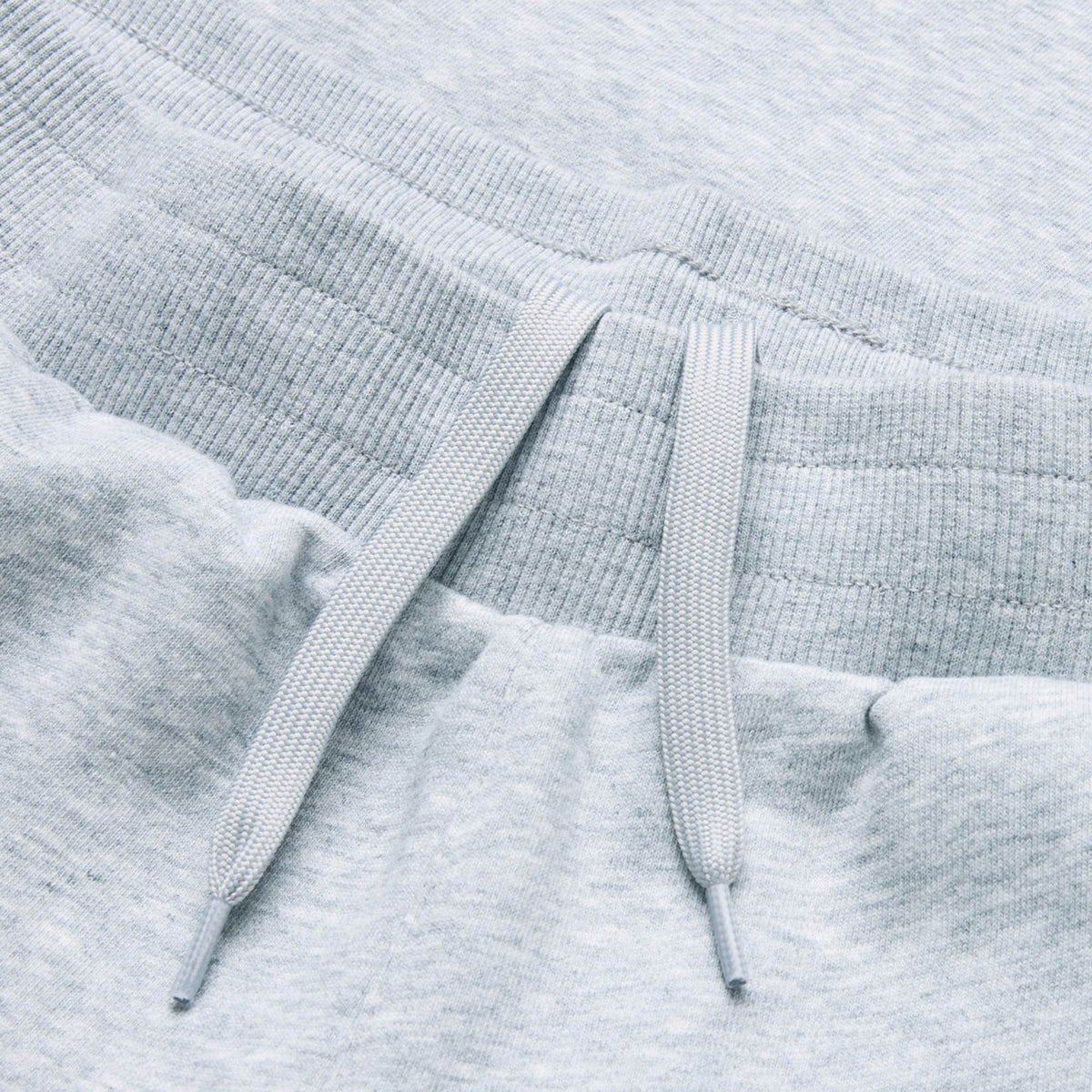 Close-up of the Canterbury Rakaia 2.0 Fleece Pant waistband in light gray, showcasing ribbed elastic material and two flat drawstrings for optimal comfort and style, crafted with premium fleece construction inspired by Canterbury’s renowned design.