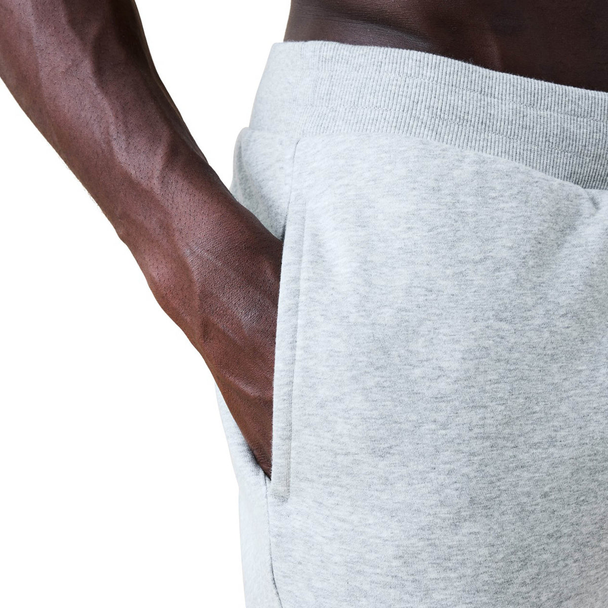 A person wearing Canterbury Rakaia 2.0 Fleece Pant by Canterbury in light gray has their right hand in the pocket. The background is white.