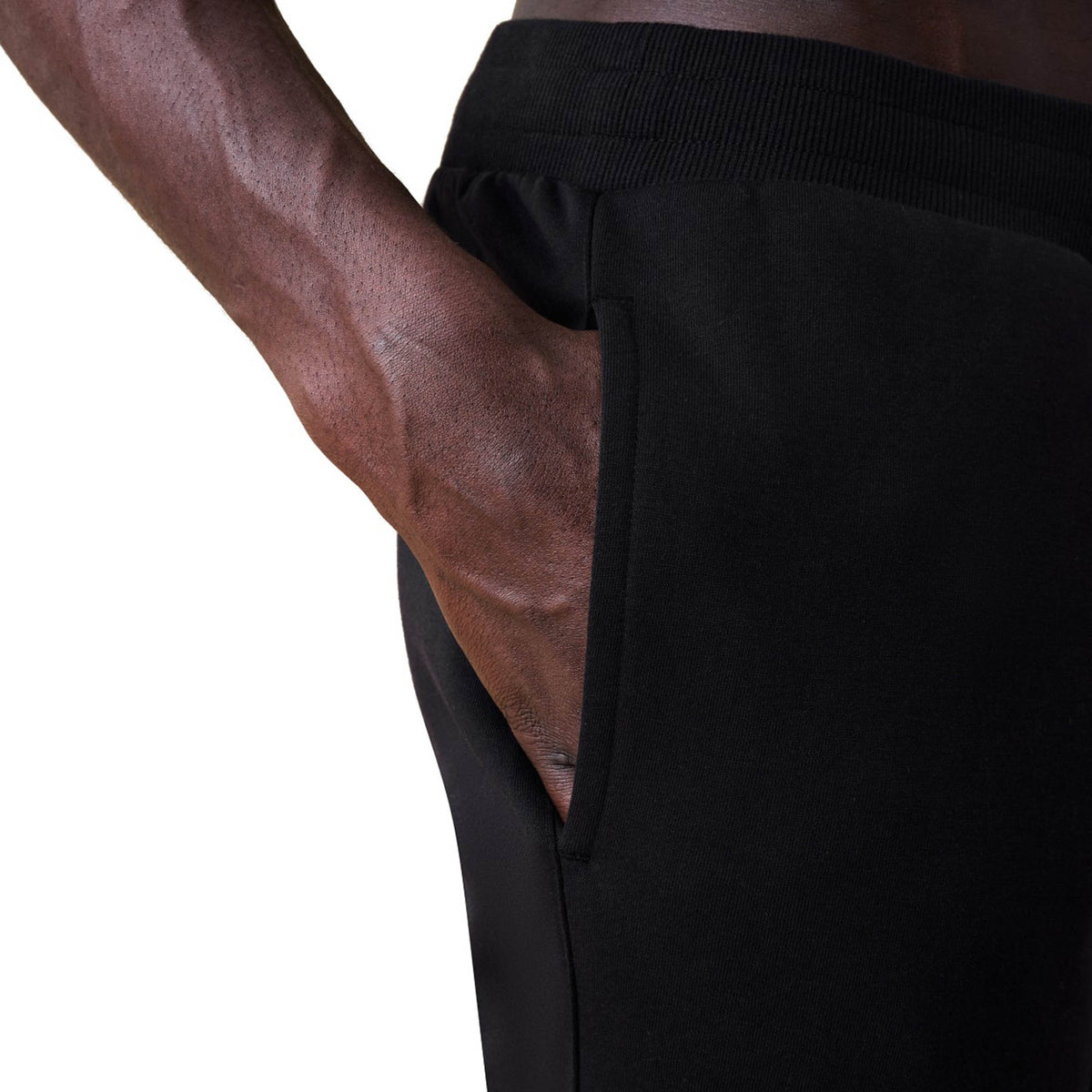A person wearing Canterbury Rakaia 2.0 Fleece Pants by Canterbury, with their right hand in the pocket, photographed from the waist to mid-thigh.