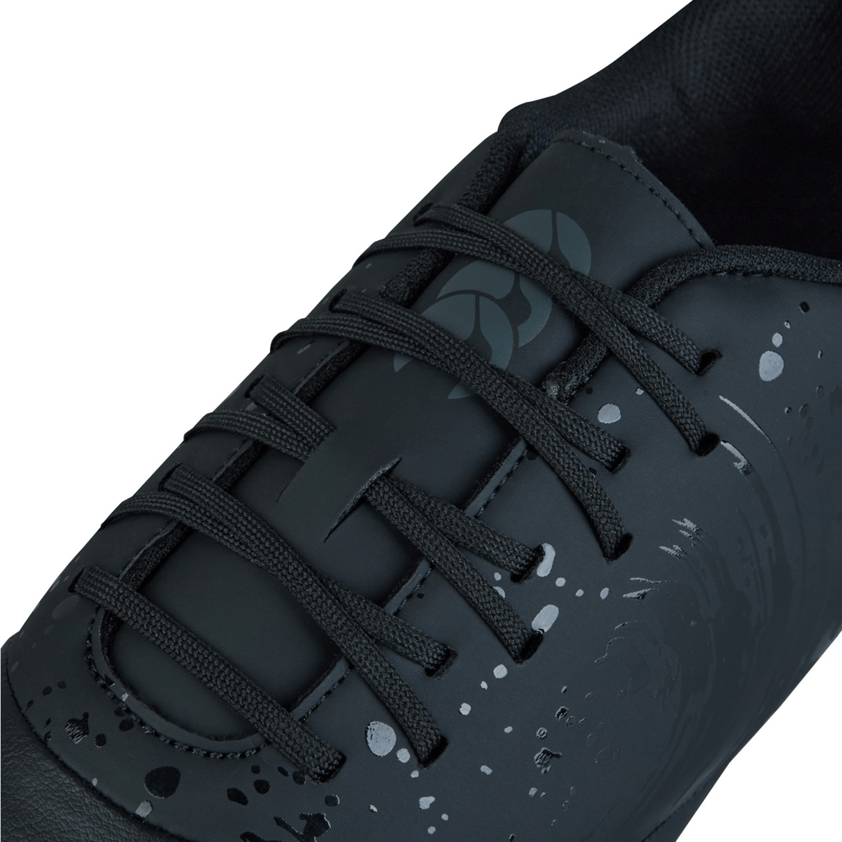 Close-up of the Canterbury Phoenix Genesis Team SG in Black/Silver Metallic, featuring a grey abstract design and black laces against a white background, reminiscent of the sleek performance found in Canterbury rugby boots.