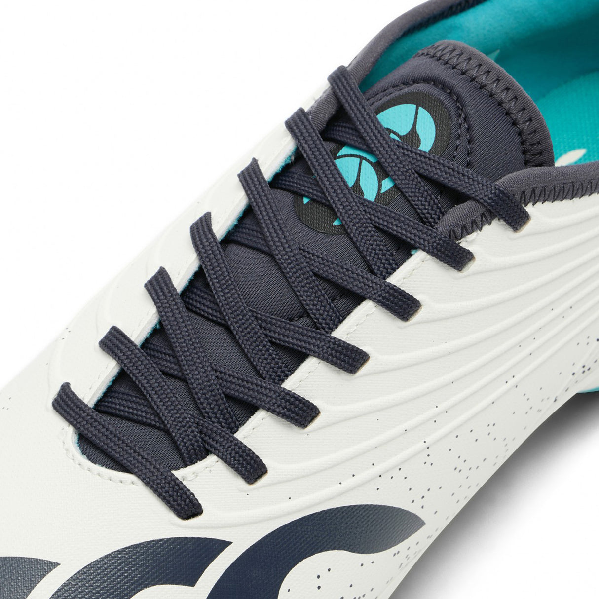 Close-up of the Canterbury Stampede Groundbreak Pro SG in White/Baltic Green, showcasing black laces, a stitched tongue with the Canterbury logo, and a teal inner lining—perfect for players who want the stability and traction of premium soft ground rugby boots.