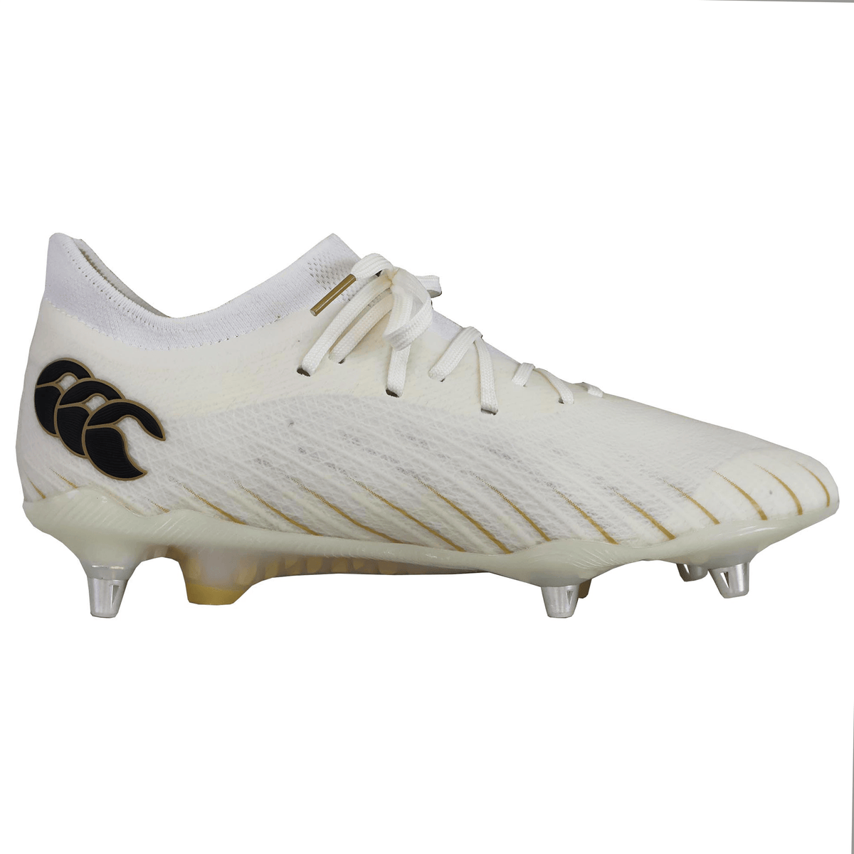 The Canterbury Speed Falcon Elite SG boots are white soft ground boots with metal studs, a black Canterbury logo on the side, and subtle gold detailing, shown in side profile on a plain background.