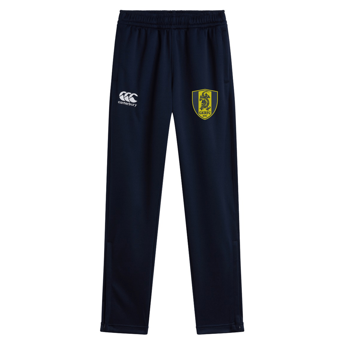 The Gotham Knights Stretch Tapered Pant by EMB Canterbury offers both style and functionality with a pair of navy blue athletic pants featuring a lion crest logo on the right leg, the Canterbury brand logo on the left leg, and zip pockets. These quick-dry pants are designed for optimal performance.