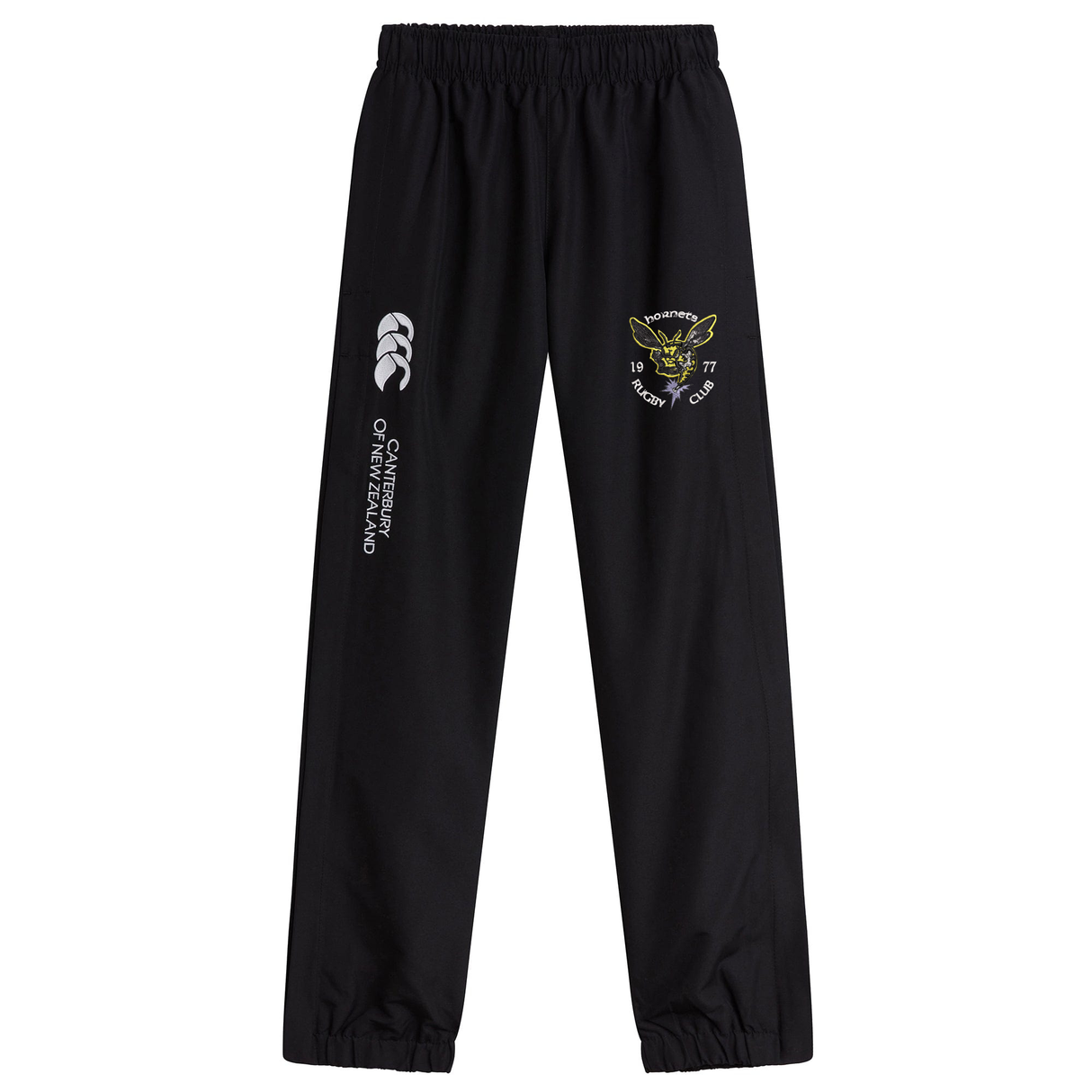 The Hornets Rugby Club 1977 Cuffed Hem Stadium Pant by EMB Canterbury features black athletic pants with an elastic waistband and signature Canterbury cuffed hem, showcasing a white Canterbury of New Zealand logo alongside a yellow embroidered Papanui Rugby Club emblem on the left leg—carefully designed for both comfort and style.