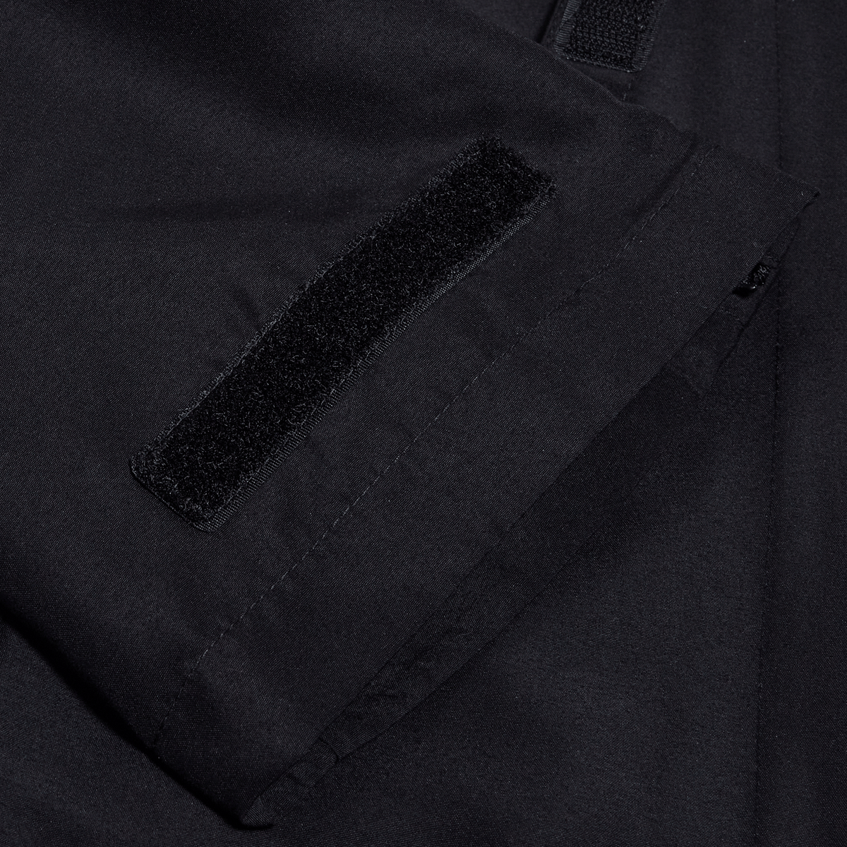 A close up of the pocket of a Canterbury black jacket.