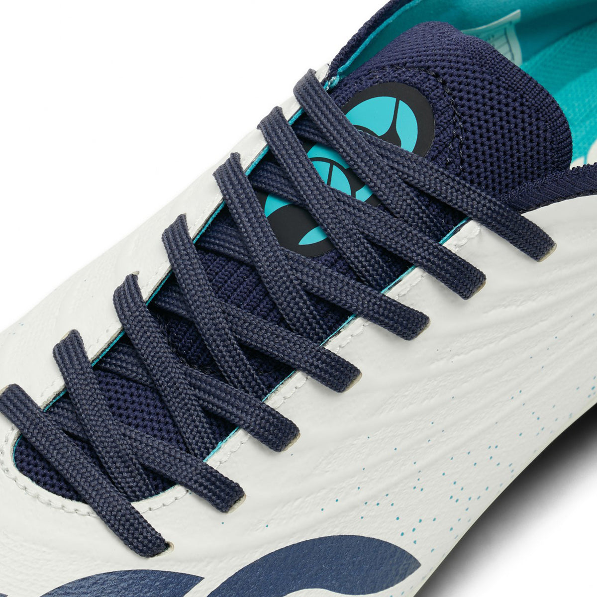 Close-up of a white and Baltic Green Canterbury Stampede Groundbreak Elite SG rugby boot with navy laces and a teal interior.