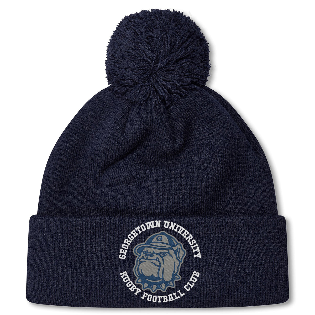 The Georgetown University RFC Pom Pom Beanie by Canterbury features a navy blue knit, fleece lining, pom-pom, bulldog graphic, and club logo—a perfect rugby fan hat from EMB Canterbury.