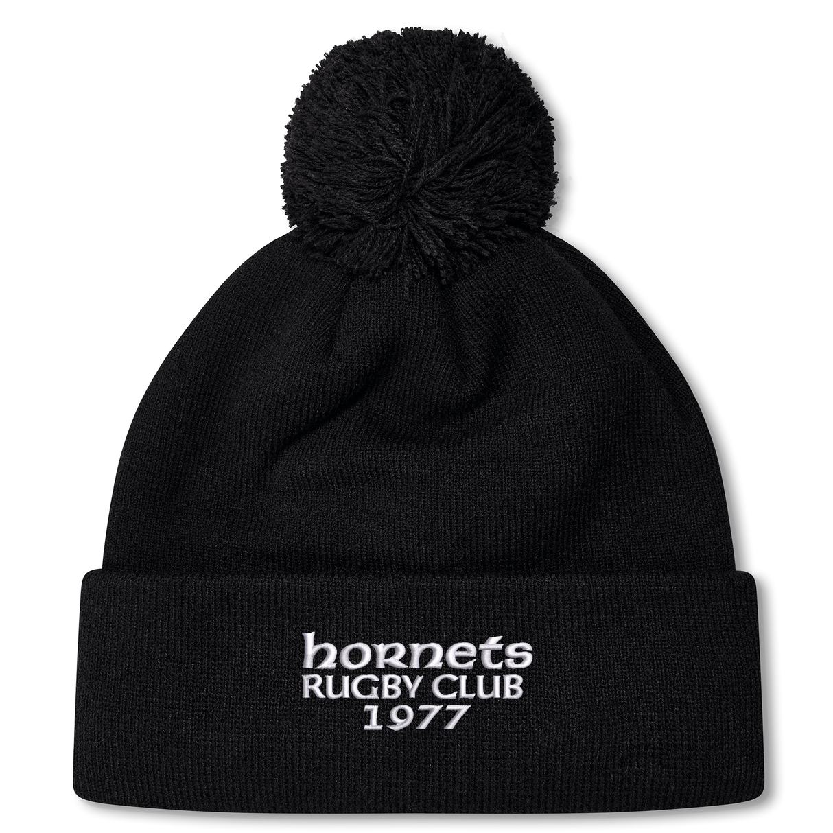 The Hornets Rugby Club 1977 Pom Pom Beanie by Canterbury from EMB Canterbury features a black knit design in the classic Canterbury bobble hat style, with a pom-pom on top and white embroidered "hornets RUGBY CLUB 1977" text on the front cuff.