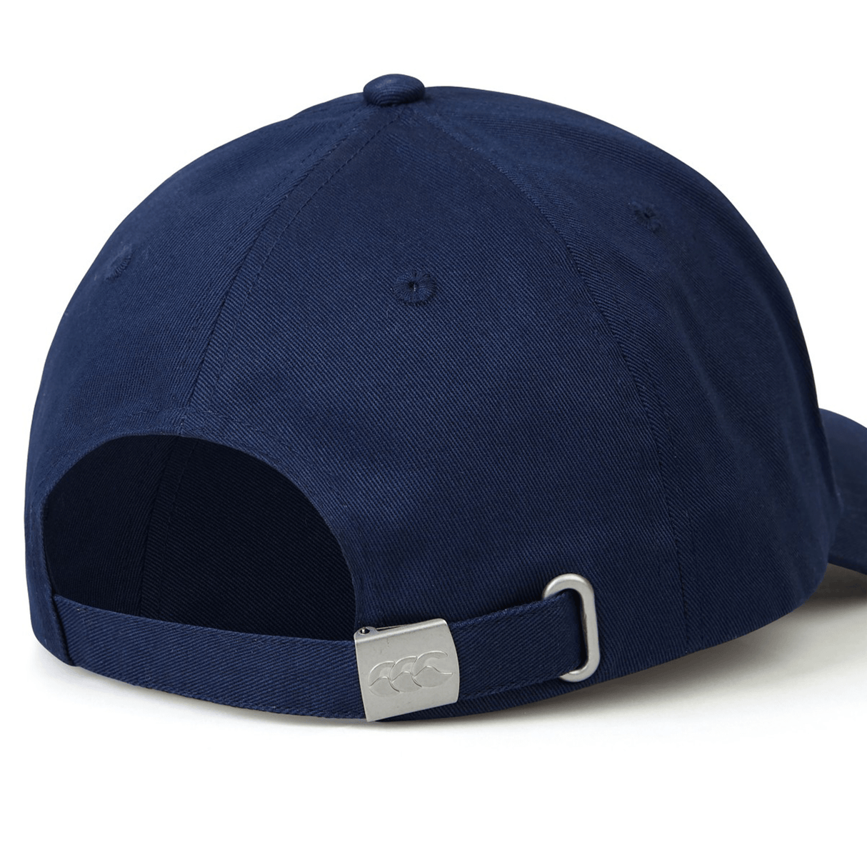 A USA Shield Flex Drill Cap by EMB Canterbury is displayed from the back, highlighting its navy blue color and adjustable strap with a metal clasp.