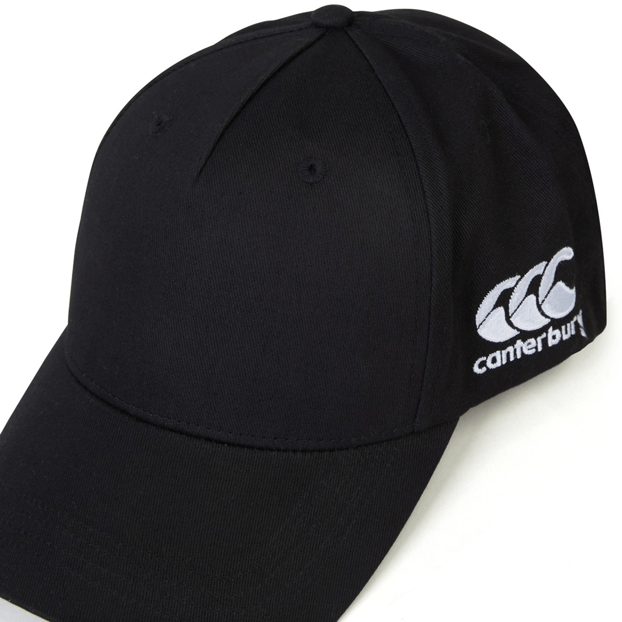 A black World Rugby Shop Flexfit Drill Cap by Canterbury with a curved brim and an embroidered white EMB Canterbury logo on the side.