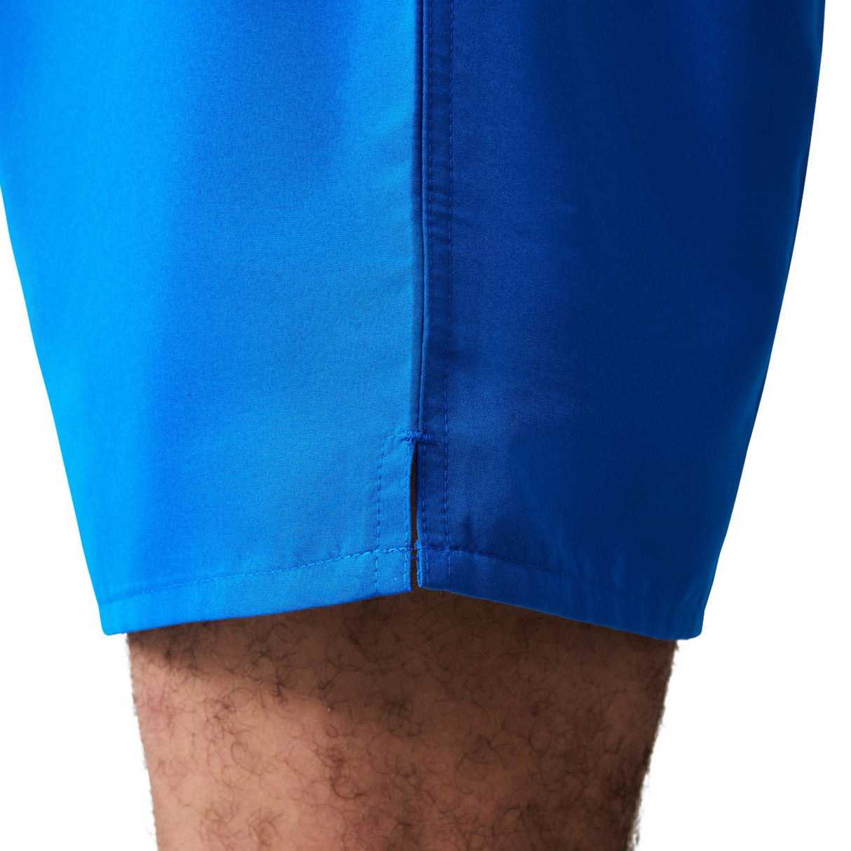 Close-up of a person's upper leg wearing Canterbury Uglies Tactic Shorts in bright blue, highlighting the side seam and part of the hem.