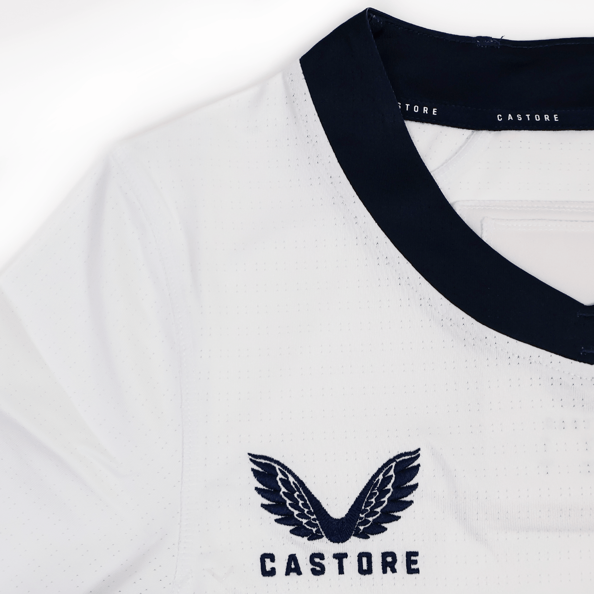 Close-up of the Women's USA Rugby 7s Olympic Pro Away Jersey by Castore—a white athletic shirt with a black collar and embroidered Castore logo, from the Olympic Pro collection.