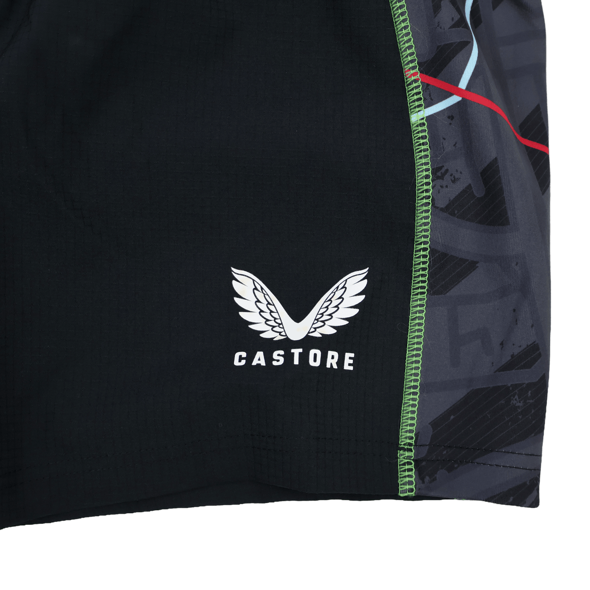 Close-up of the Harlequins 22/23 3rd Pro Short by Castore, showcasing black fabric with the white wings logo and green seam stitching, inspired by classic rugby style.