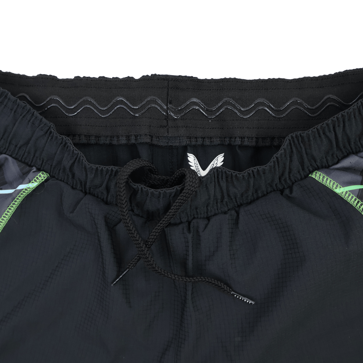 Close-up of the waistband on the Castore Harlequins 22/23 3rd Pro Short, showing a drawstring, elastic band with a wavy pattern, and green accent lines on the sides.