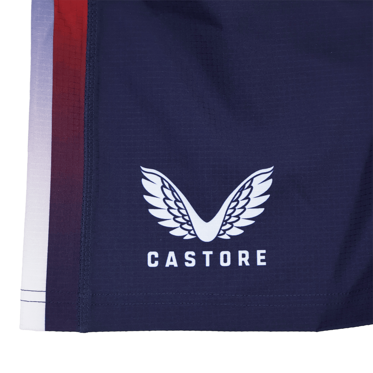 Navy blue USA Rugby 22/23 Pro Home Shorts by Castore, featuring the signature logo—white wings above the brand name—and a bold red, purple, and white gradient stripe along the edge. Official USA Rugby apparel.