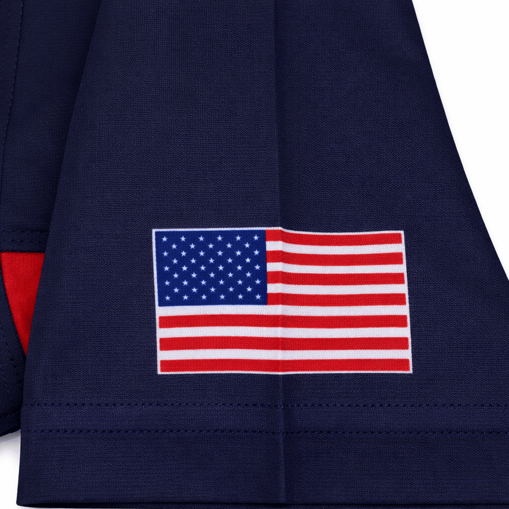 A close-up of the USA Rugby 22/23 Pro Away Jersey by Castore in navy blue, featuring a printed United States flag near the hem.