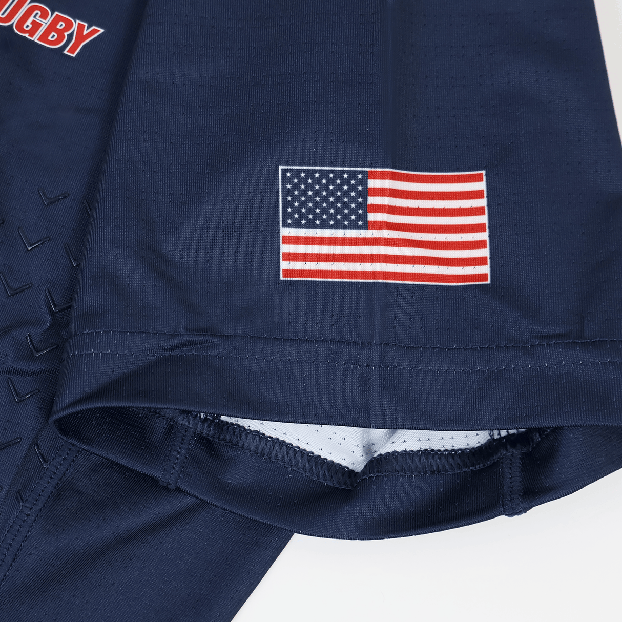 A close-up of the USA Rugby 23/24 Training Jersey by Castore, showcasing a printed United States flag on the sleeve.