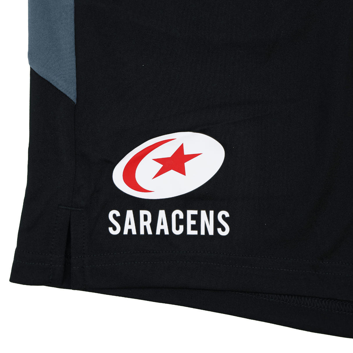 Close-up of black Saracens 24/25 Pro Players Gym Training Short by Castore, featuring the Saracens logo—a red star and crescent inside a white oval above "SARACENS.