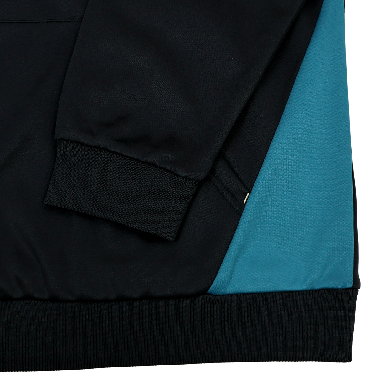 Close-up of the Bath 23/24 Hoodie by Castore showing the black sleeve with ribbed cuff and teal blue side panel, highlighting detailed stitching—a must-see for fans of Castore’s Bath Rugby gear.