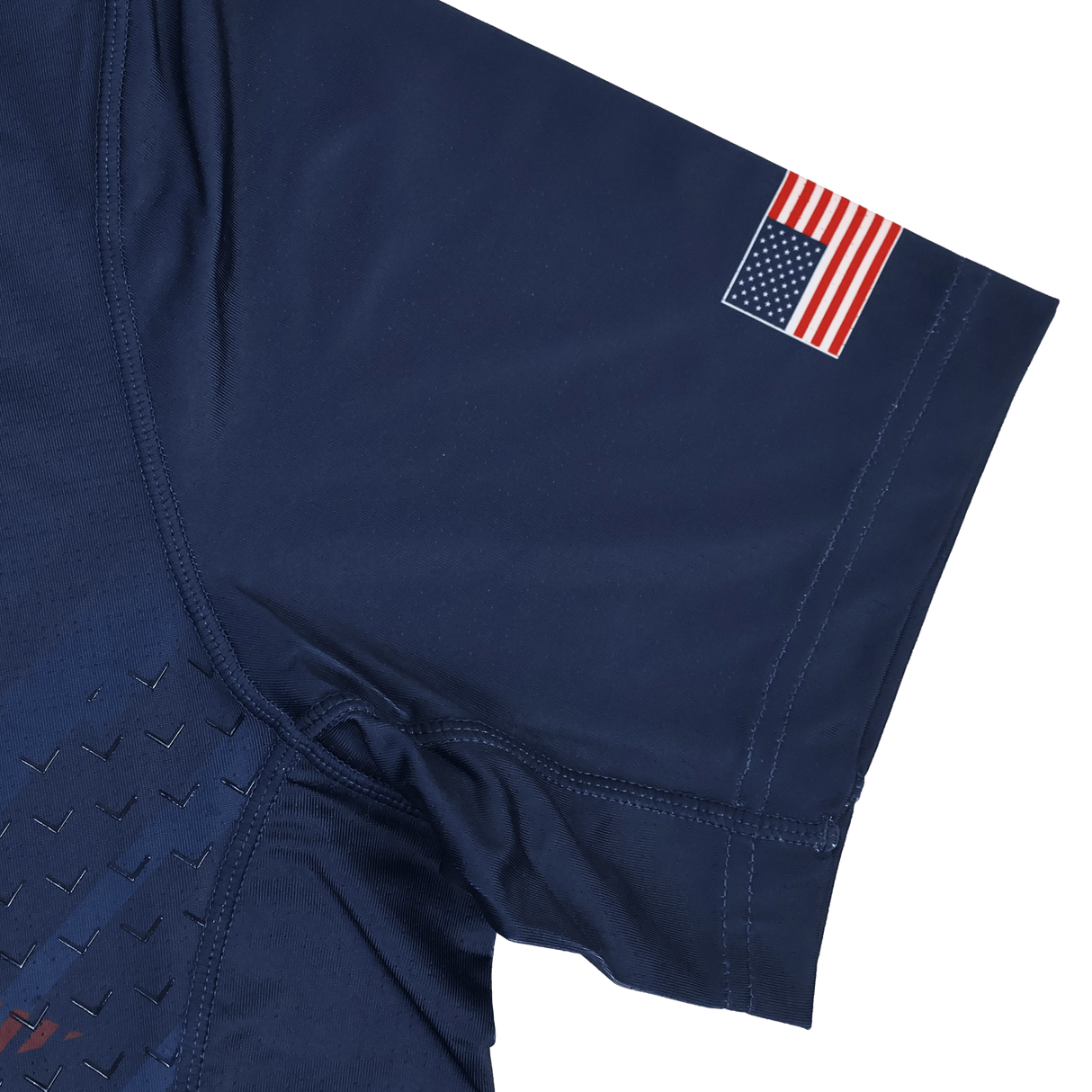 The USA Rugby 24/25 Pro Home Jersey by Castore is a navy blue short sleeve shirt inspired by the USA Rugby jersey, featuring a small American flag patch on the upper sleeve.