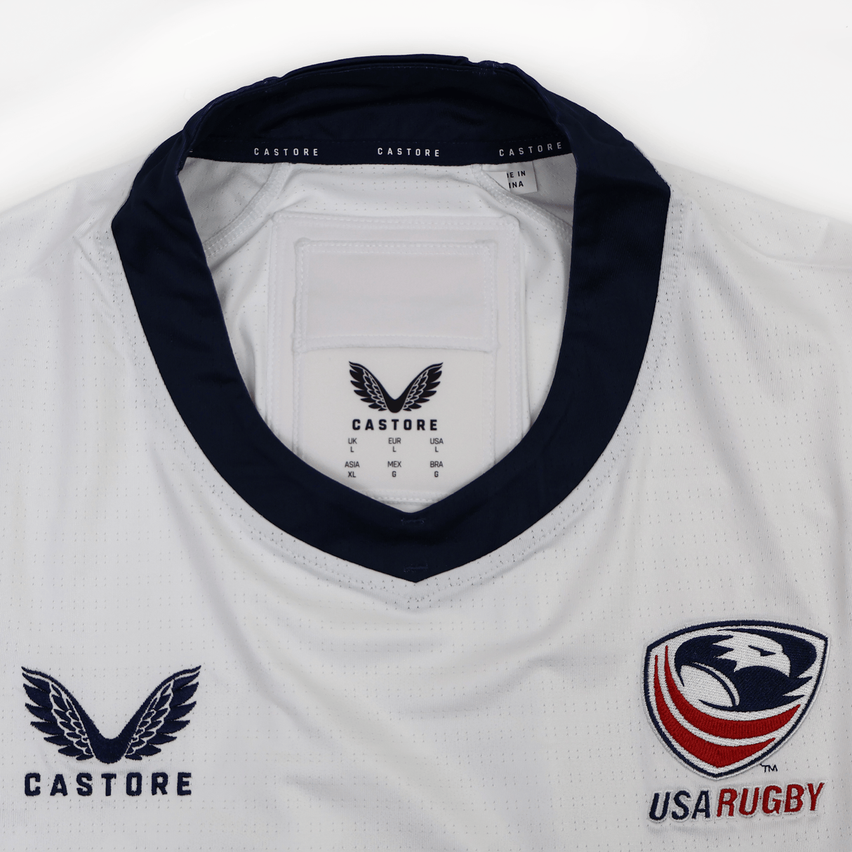 The USA Rugby 24/25 Pro 7s Away Jersey by Castore is white with a navy collar, featuring the Castore logo on the left chest and neck label, and the USA Rugby eagle on the right chest.