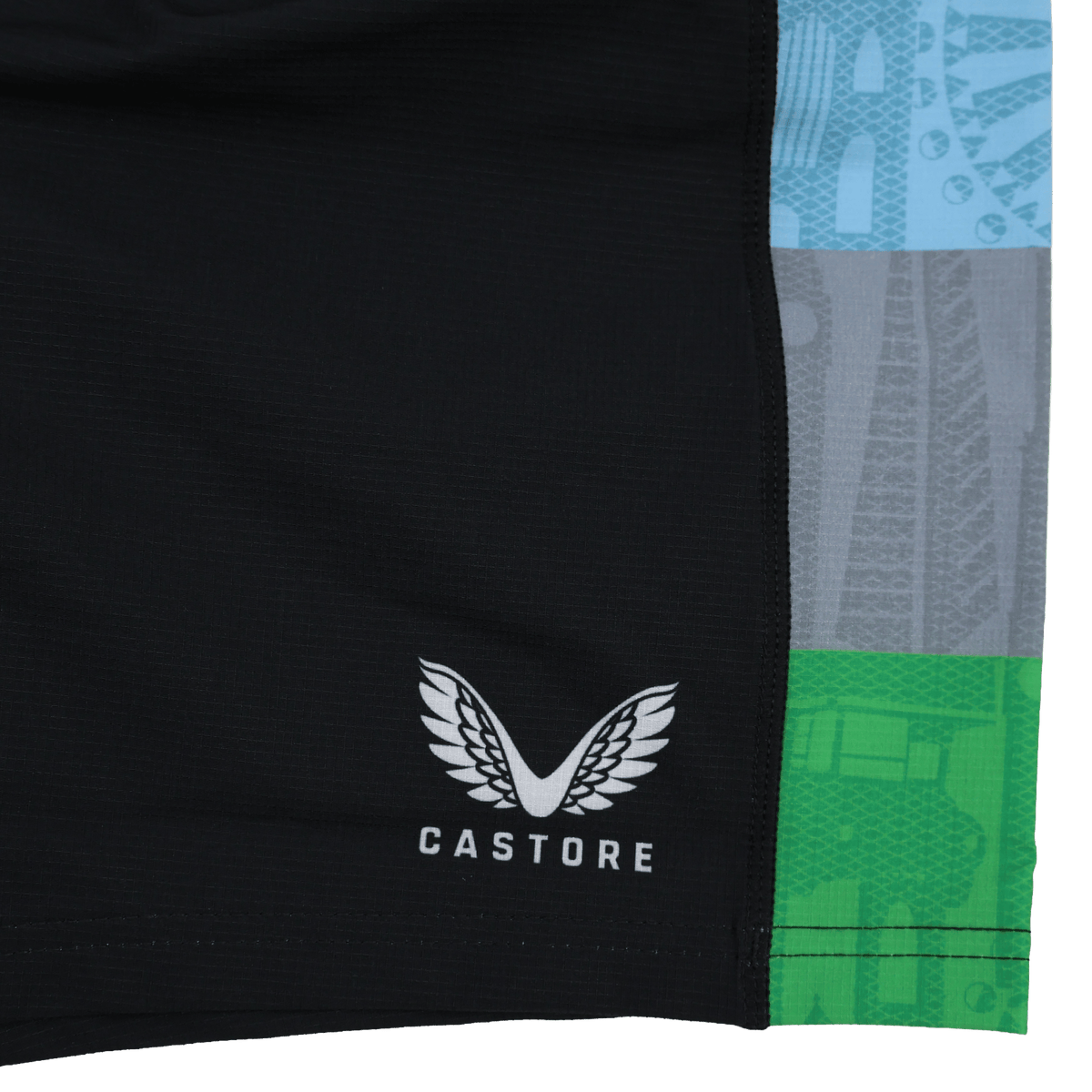 Close-up of black Harlequins 24/25 Pro Home Short by Castore with white logo and name, featuring vertical blue, gray, and green patterned stripes on the right—part of the professional rugby teamwear collection.