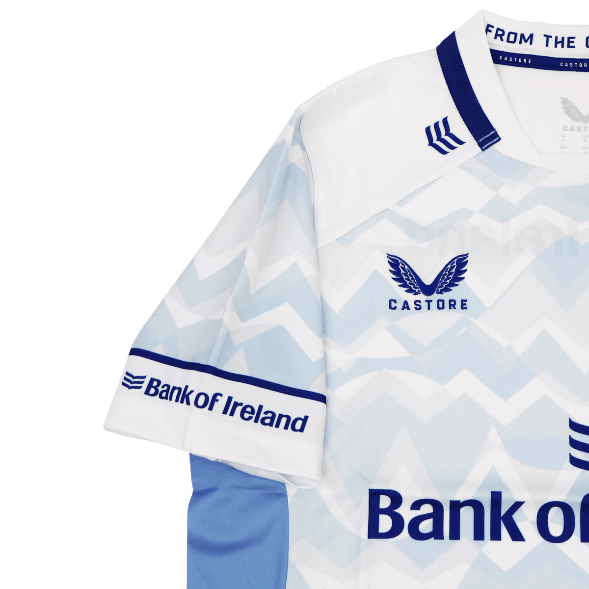 The Leinster 24/25 Replica Away Jersey by Castore features a striking light blue and white zigzag design, Bank of Ireland logos, and bold blue collar and sleeve accents—a must-have shirt for passionate Leinster Rugby fans.