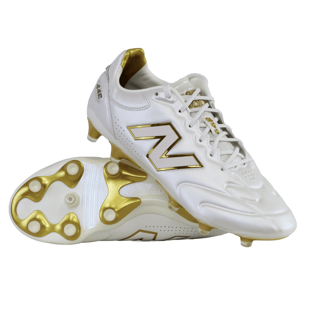 A pair of New Balance 442 Elite FG v3 soccer cleats in Sea Salt/Gold Metallic, one upright and one on its side, showcase DynamicTouch Tech for superior control and gold-accented firm ground studs.