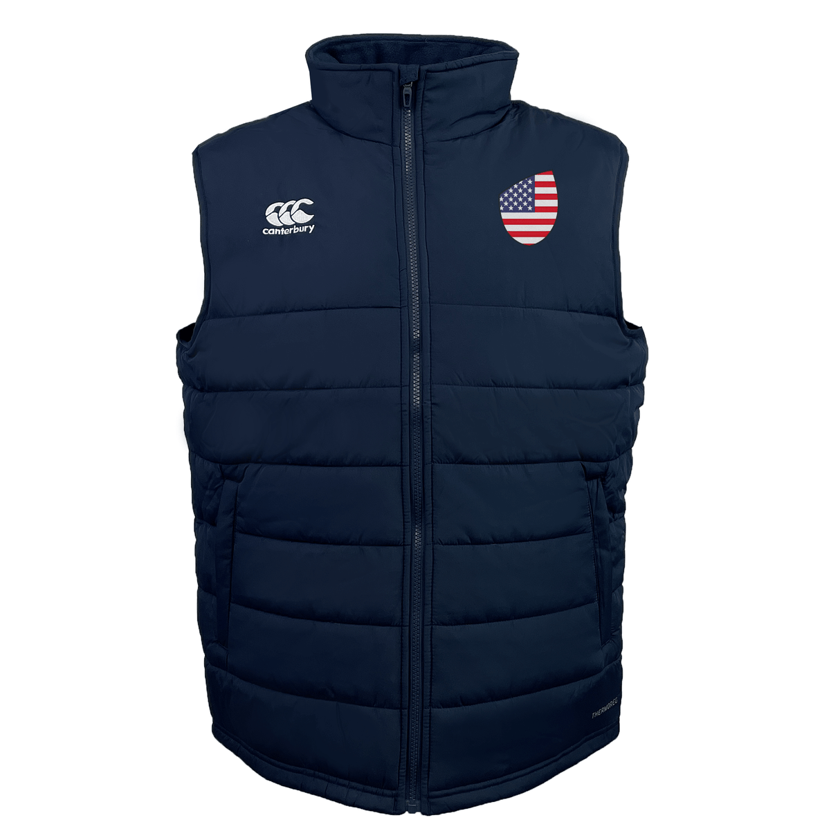 The USA Shield Core Gilet by EMB Canterbury is a navy blue puffer vest with an American flag patch on the left chest, a company logo on the right chest, Thermoreg insulation, and a front zipper.