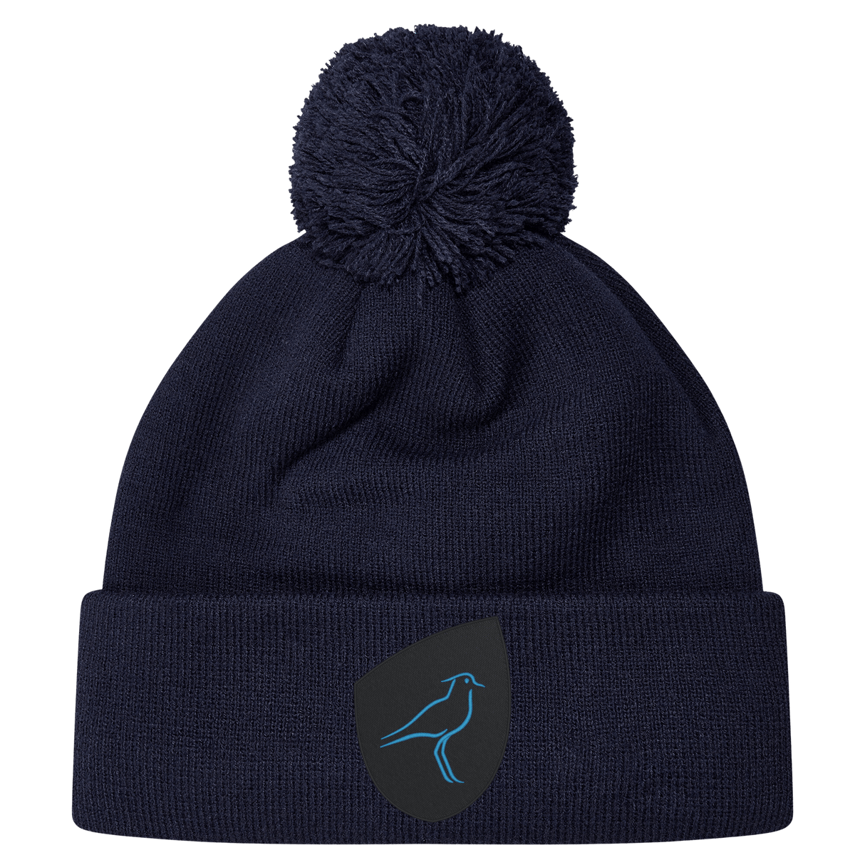 The Uruguay Shield Pom Pom Beanie by EMB Canterbury is dark blue with a playful pom-pom on top, adorned with a small patch showcasing a blue bird logo.