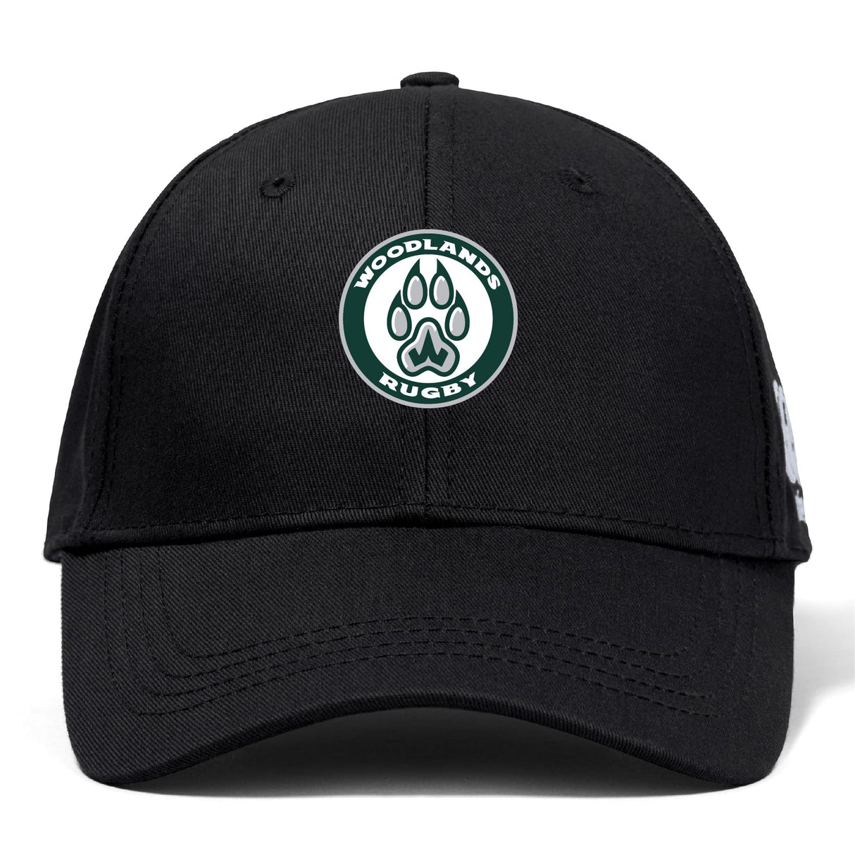The Woodlands Youth Flexfit Drill Cap by Canterbury is a black cap from EMB Canterbury, featuring the embroidered Woodlands Rugby logo with a paw print inside a green and white circle on the front.