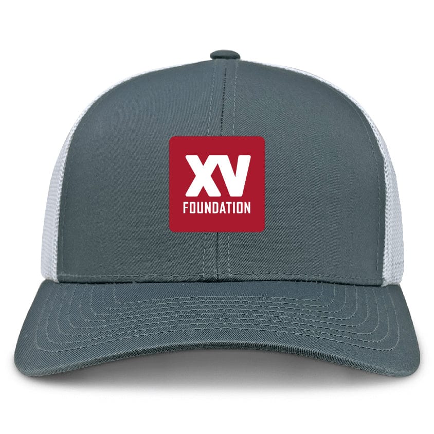 The XV Foundation Retro Trucker Cap by EMB S&S Activewear is a gray and white trucker hat with a snapback, featuring a red square patch with white "XV FOUNDATION" text. Made from a comfortable polyester/cotton blend.
