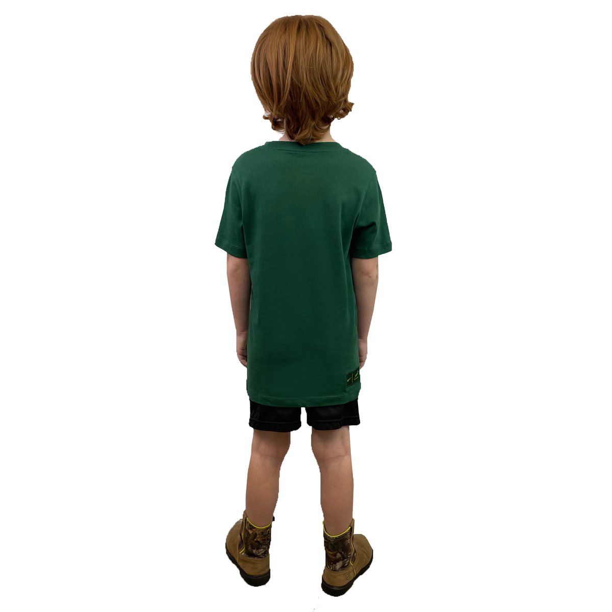 A young child with light brown hair faces away, wearing a green Nike Youth Springboks 25 Bokke T-Shirt, black shorts, and tan boots against a white background.