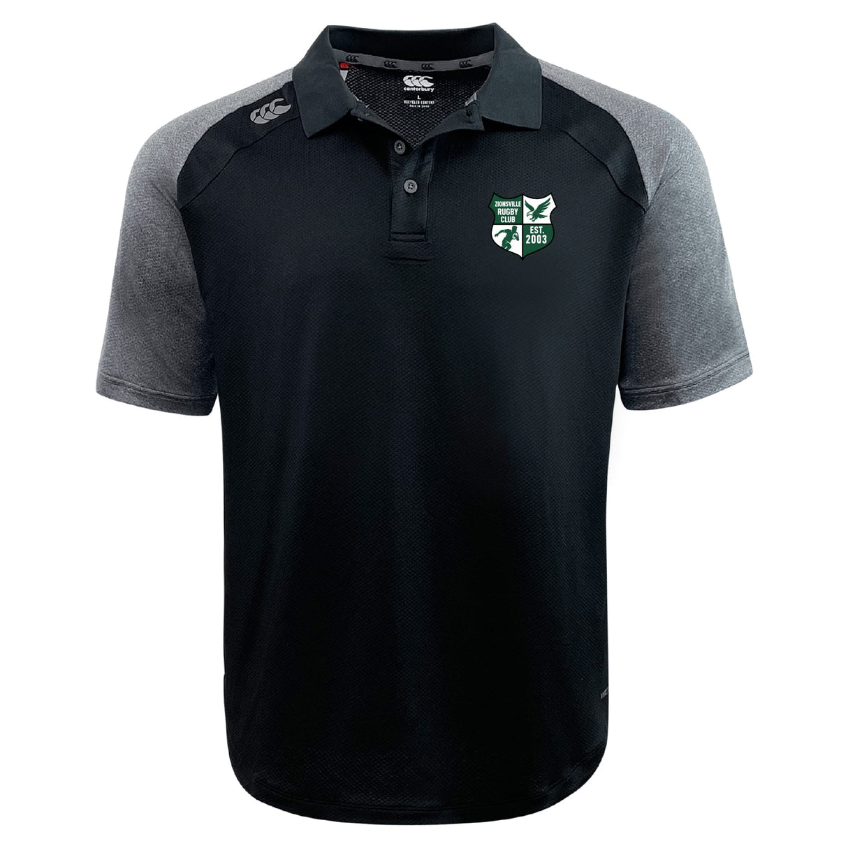 The Zionsville Rugby Club Elite Polo by EMB Canterbury features Vapodri fabric, short sleeves, buttons, a shoulder Canterbury logo, and an embroidered green and white crest on the chest in black and gray.