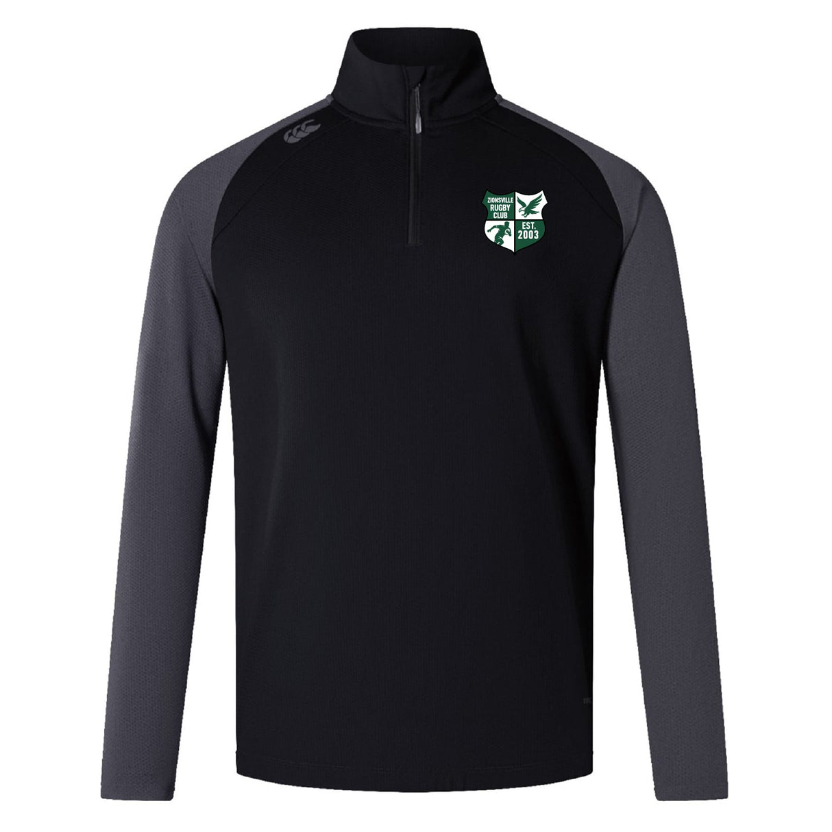 The Zionsville Rugby Club Elite First Layer by EMB Canterbury is a black long-sleeve quarter-zip pullover with dark gray sleeves, VapoDri tech for moisture control, and a green and white embroidered logo on the left chest.
