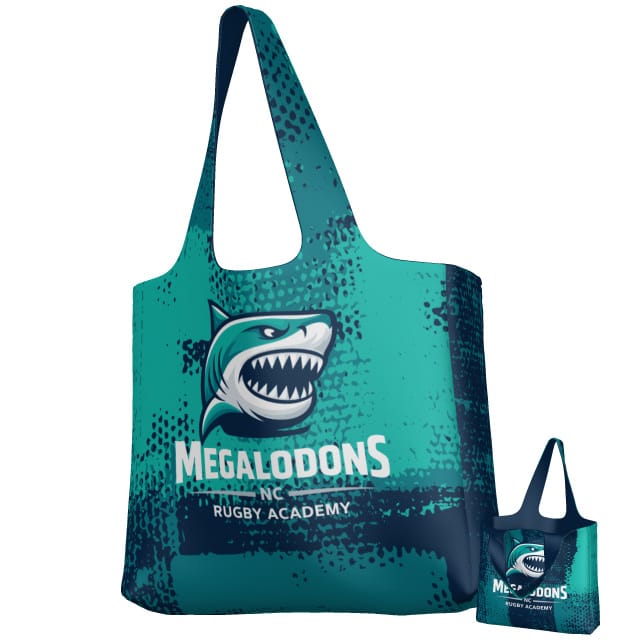 Teamatical's NC Megalodons DNA Packable Zip Tote features teal and navy polyester, a bold shark logo, and "Megalodons Rugby Academy" text. Includes a smaller folded tote—ideal for rugby fans on the go.