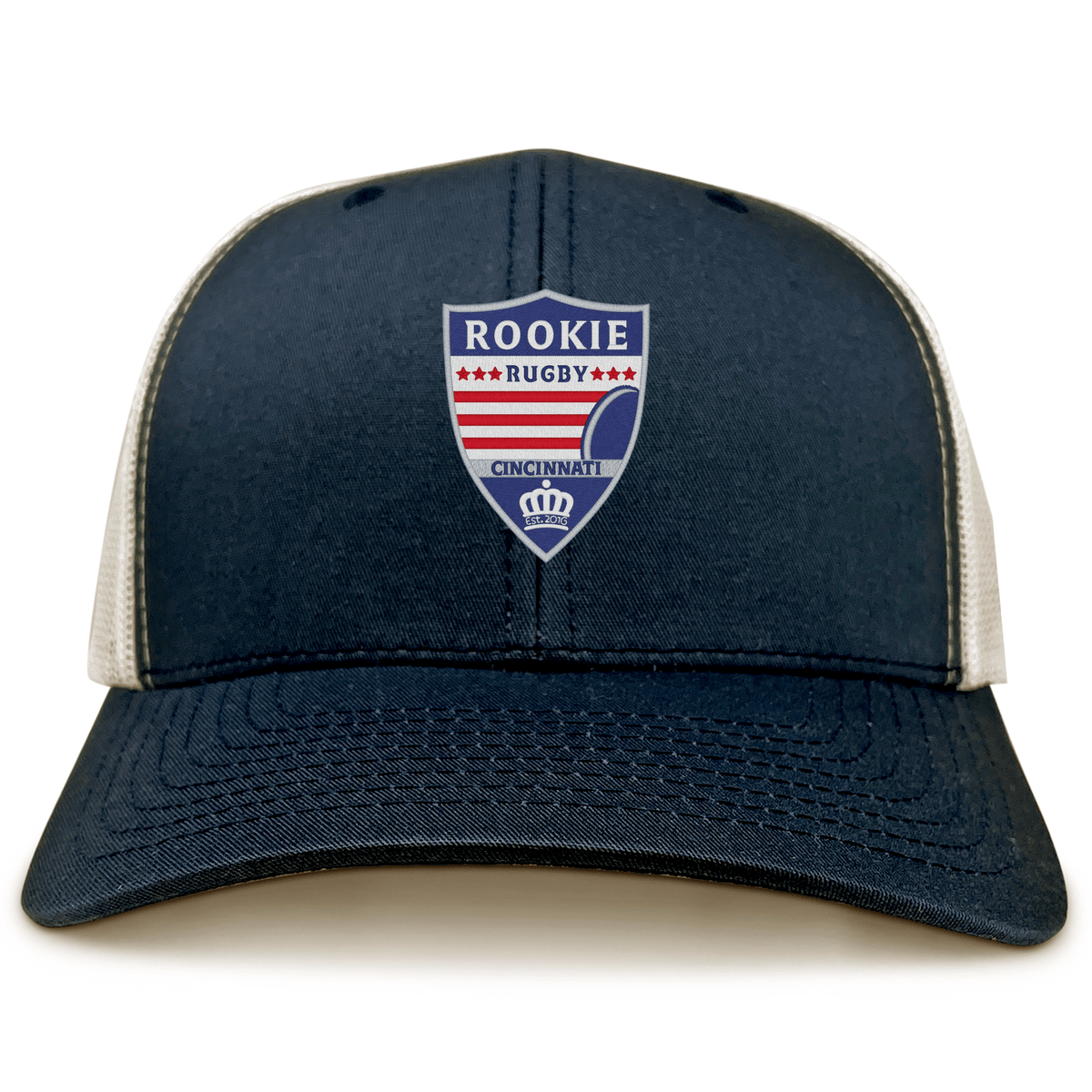 The Cincinnati Rookie Rugby Retro Trucker Cap by EMB S&S Activewear features a navy and white design, an embroidered "Rookie Rugby Cincinnati" shield logo on the front, and a snapback closure for adjustable comfort.