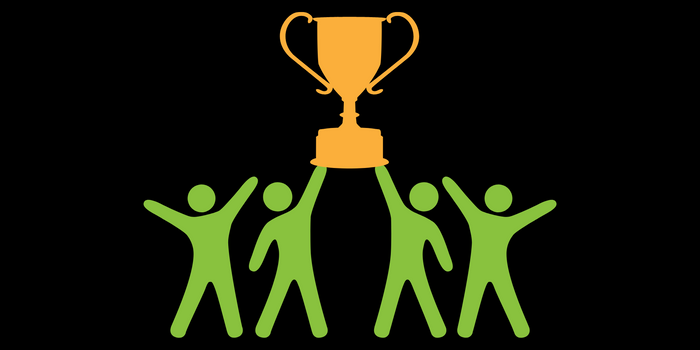 Four green people holding up a gold trophy