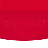 The Wales 25/26 Replica Home Cotton Jersey by Macron features red fabric with "CYMRU" subtly embossed in large capitals across the lower section, inspired by classic Wales rugby jerseys.